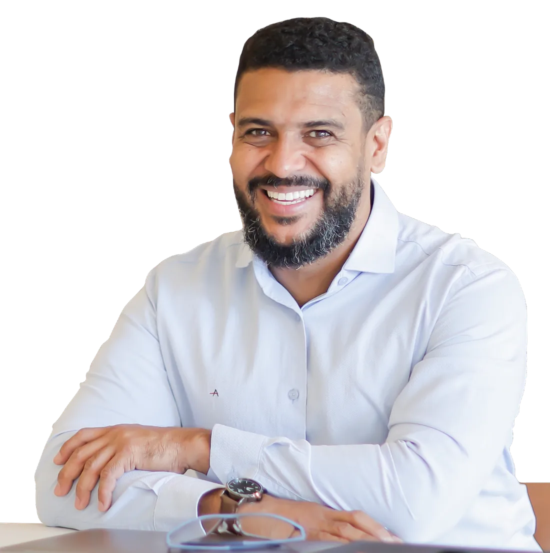 Jeremias, psicólogo clínico, sorrindo à mesa de trabalho